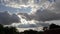 Time lapse of white clouds seen from the roof of a residential village