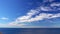 Time-lapse, white sailboat moving fast on blue sea, beautiful clouds in the sky