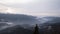 Time-lapsed sunrise, city between mountains and cloudy sky and fog