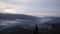 Time-lapsed sunrise, city between mountains and cloudy sky and fog