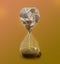 Time is money. Hourglass full of coins converting into golden sand on background