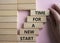 Time for a new start symbol. Wooden blocks with words Time for a new start. Beautiful pink background. Businessman hand. Business