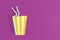 Time for party. Female legs peek out from paper cup for popcorn on a purple background.