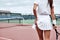 It is time to act! Woman is going to play tennis on the court
