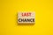 Time to last chance symbol. Concept words Last chance on wooden blocks on a beautiful yellow background. Business and time to last