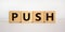 Time to push. Wooden block form the word `push` on beautiful white background. Business and push concept. Copy space