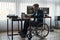 Time to read. Side view of concentrated male web developer in a wheelchair reading a book while sitting at his workplace