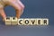 Time to recover symbol. Businessman turns wooden cubes and changes the word `cover` to `recover`. Beautiful grey background.