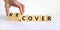 Time to recover symbol. Businessman turns wooden cubes and changes the word `cover` to `recover`. Beautiful white background.