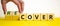 Time to recover symbol. Businessman turns wooden cubes and changes the word `cover` to `recover`. Beautiful yellow table, whit