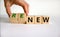 Time to renew. The words `new` and `renew` on wooden cubes. Male hand.  Beautiful white background, copy space