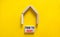 Time to rent house symbol. Concept words `Time to rent` on wooden blocks near miniature house. Beautiful yellow background, copy