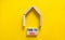 Time to sell house symbol. Concept words `Time to sell` on wooden blocks near miniature house. Beautiful yellow background, copy