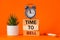 Time to sell symbol. alarm clock and time to sell, word concept on wooden blocks. Beautiful orange background, succulent on desk,