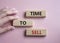 Time to Sell symbol. Concept words Time to Sell on wooden blocks. Businessman hand. Beautiful pink background. Business and Time