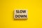 Time to slow down symbol. Concept words Slow down on wooden blocks on a beautiful yellow background. Business and slow down