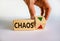 Time to stop chaos symbol. Businessman holds a cubes with up icon. Wooden cubes with word `chaos`. Beautiful white background.