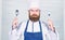 Time to try taste. Chef serious face hold spoon and fork. Man handsome with beard holds kitchenware on white background