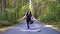 Time to yoga! fatty woman dressed in black tshirt and black sportive pants is doing yoga on purple mat on the road in the autumn