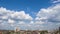 Timelapse blue sky with white cumulus clouds above the city