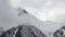 Timelapse close-up of the tops of snow-capped mountains on which clouds float. Mountain weather forecast