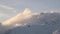 Timelapse clouds flow in the mountains flowing over the peaks in the evening high snow-capped mountains.