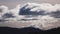 Timelapse of clouds formation coming and going across a stormy sky shot iwith mountains and hills in the foreground