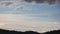 Timelapse of clouds formation coming and going across a stormy sky shot iwith mountains and hills in the foreground