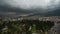 Timelapse dramatic gray cloud sky over modern big city surrounded by high mountains