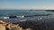 Timelapse of evening surf. Lighthouses at stone piers at harbor mouth