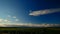 Timelapse field with sky and clouds on the horizon