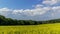 Timelapse of a field where oilseed rape is grown overlooking the surrounding countryside and the landmark of Helfstyn Castle with