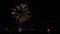 Timelapse of a firework from a beach over a coastal town. Progressive zoom on sparks at the middle of the footage. HD 1080p