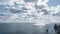 Timelapse of fluffy clouds moving in blue sky over calm sea. Abstract aerial nature summer ocean sunset sea and sky