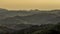 Timelapse golden sunset over mountains and valleys where fog rises and sun`s rays slowly penetrate the landscape and surrounding
