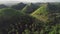 Timelapse green grass hills aerial: building, path at mounts ranges. Filipino nobody nature scape