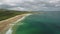 Timelapse Ireland sand beach aerial view: ocean waves, sandy coastline, white shore, greenery meadow