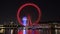 Timelapse of London Eye`s colorful lights by night reflected in River Thames