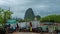 Timelapse Longtail fishing boats in the pier white storm clouds flowing fast over mountain rainforest, mangrove trees in the sea o