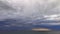 Timelapse. Movement of large dark rain clouds and rain on horizon over surface