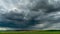 Timelapse movement of a thundercloud with rain over a wheat field. A black cloud on the eve of a tornado and a natural disaster