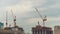 Timelapse of moving yellow tower cranes and unfinished building construction