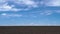 Timelapse of plowed field, soil and clouds of a bright sunny day - concept of agriculture