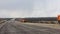 Timelapse Road construction trucks pour graph and sand.