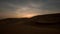 Timelapse of sunrise over sand dunes in desert