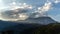 Timelapse sunset and cloudscape over mountain landscape. Moving clouds with dramatic light