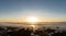 Timelapse of sunset on ocean and silhouette of surfers walking on a beach