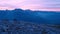Timelapse of sunset over mountain peaks. Sun goes down over sharp peaks of Alps. Pink purple sky. Colorful flare