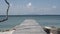 Timelapse vintage and old wooden bridge over the beach and sea at the noon with beach, sea, sunshine, rock, wind and wave around.