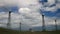 Timelapse of white clouds passing by over windmills
